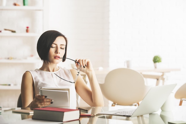 Thoughtful woman with notepad