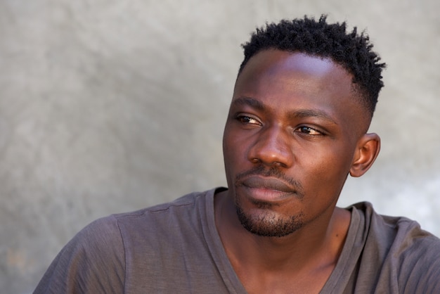 Thoughtful young african man looking away