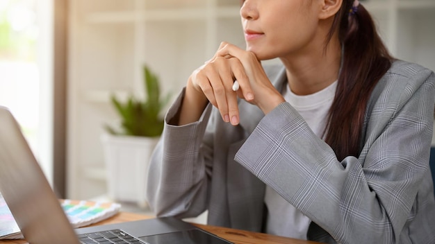 Pensiero pensieroso della giovane donna di affari asiatica premurosa che trova una strategia di marketing aziendale