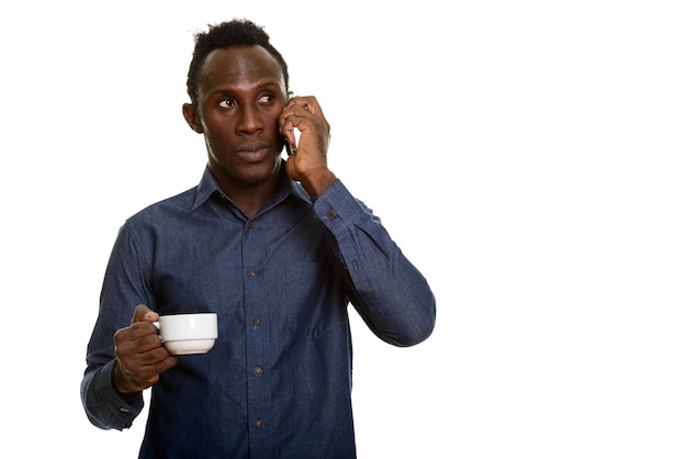 Thoughtful young black African man talking on mobile phone