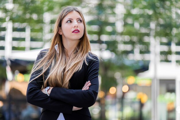 Photo thoughtful young businesswoman standing in city