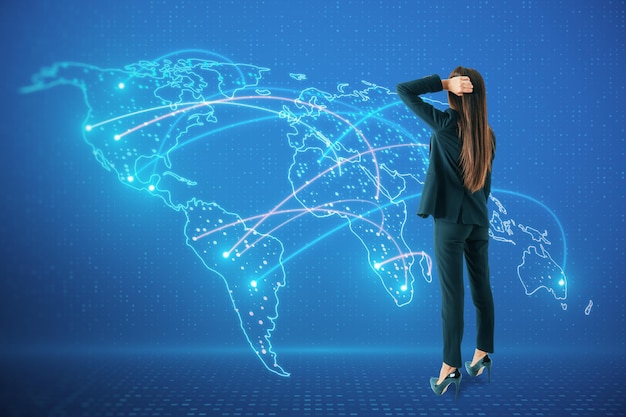 Thoughtful young european woman with abstract glowing map hologram on blue background Digital world network and technology concept