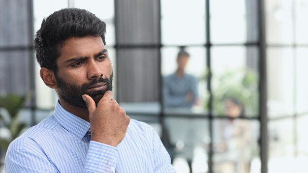 Thoughtful young handsome married bearded man in blue shirt