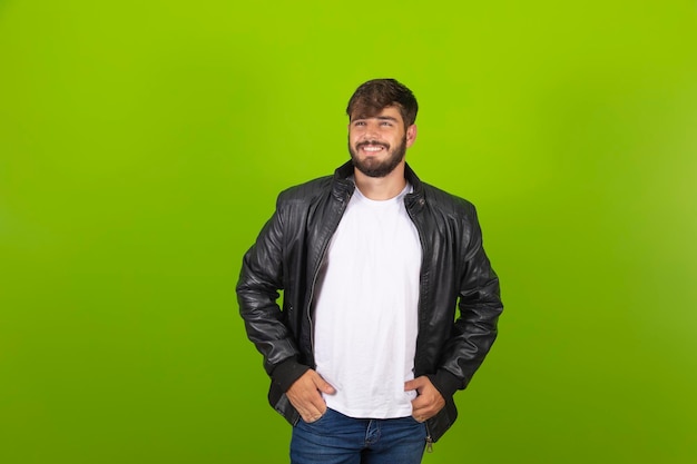 Thoughtful young man isolated over green background looking aside