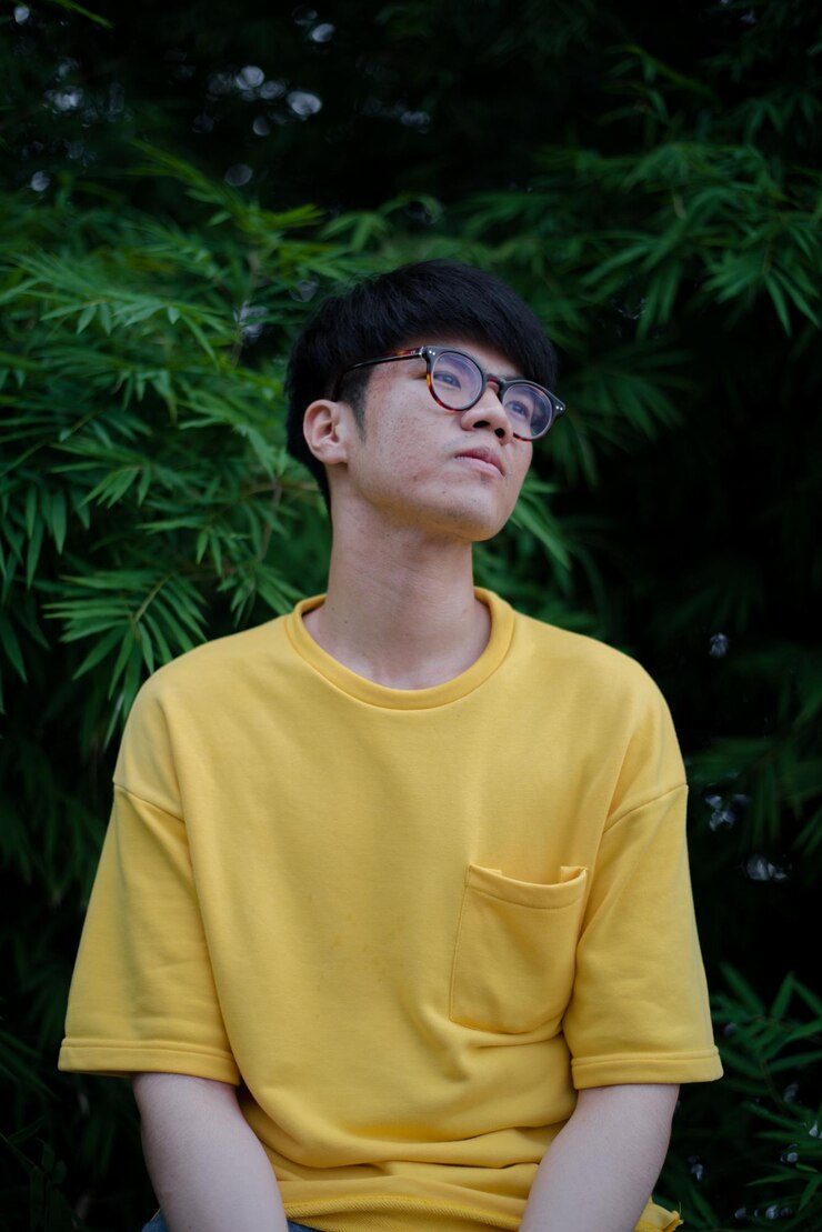Photo 식물 에 앉아 있는 사려 깊은 젊은 남자