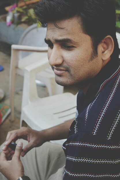 Photo thoughtful young man sitting on chair at home