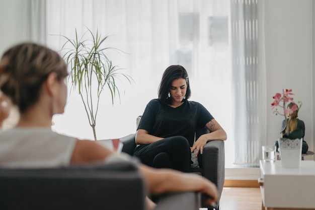 Thoughtful young woman after hearing a question from her\
psychologist