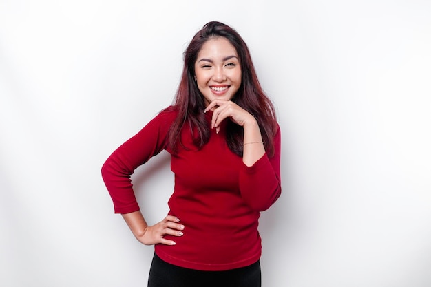 A thoughtful young woman dressed in red while looking aside isolated by white background