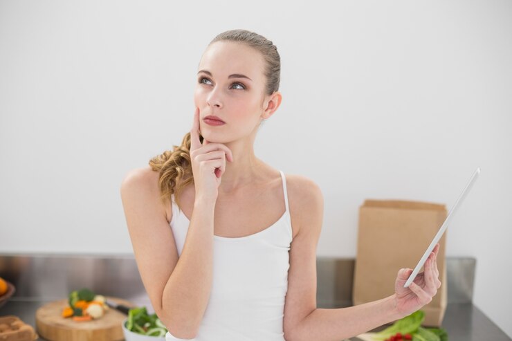 Thoughtful young woman holding her digital tablet 