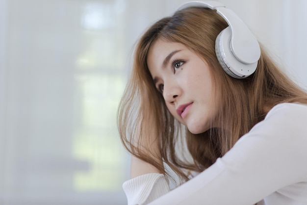 写真 思いやりのある若い女性がヘッドフォンで音楽を聴いています