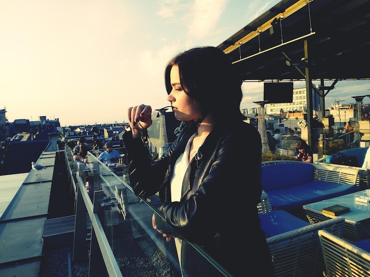 Photo thoughtful young woman standing by railing in city