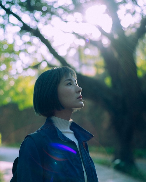 thoughtful young woman standing in forest