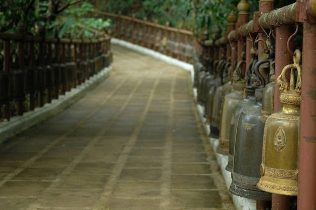 Thousand of bronze, silver and gold big bells on the way to temple that's on a hill. 