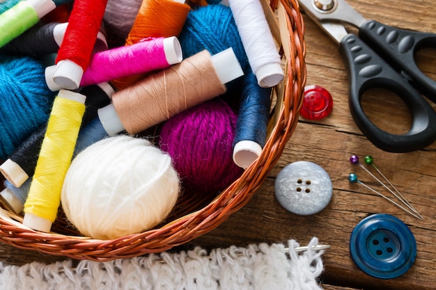 Thread and yarn in a basket next to the buttons and scissors