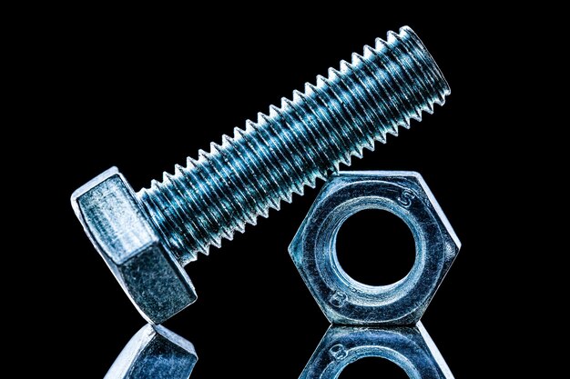 Photo threaded construction nut bolt on black background