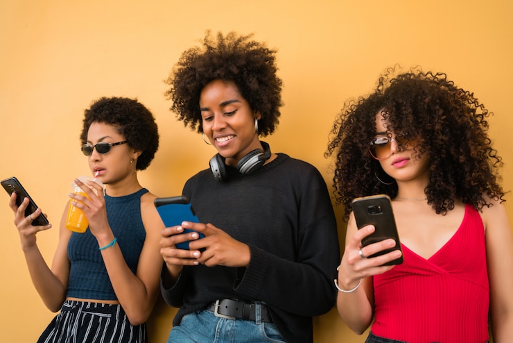 Photo three afro friends using their mobile phone