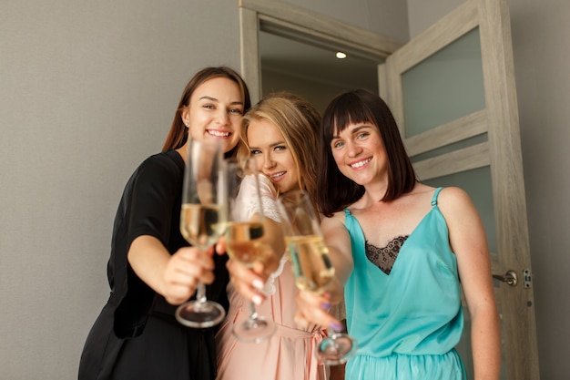 Three amazing lovely girls posing at camera, at the hen-party