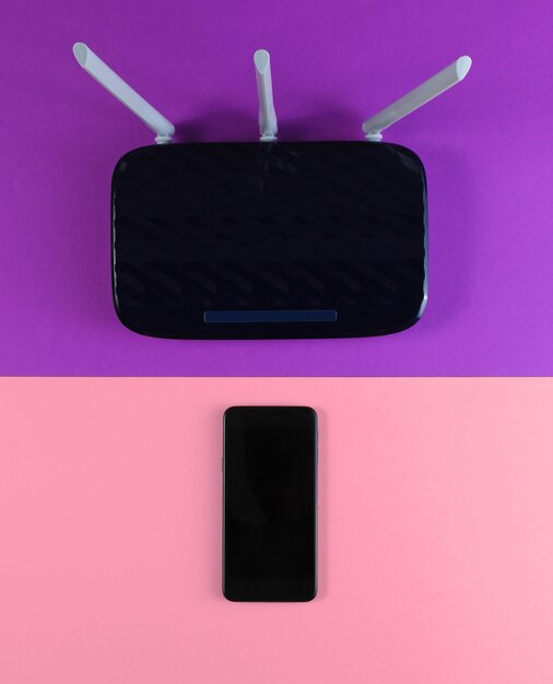 Foto router wifi a tre antenne con smartphone su carta colorata