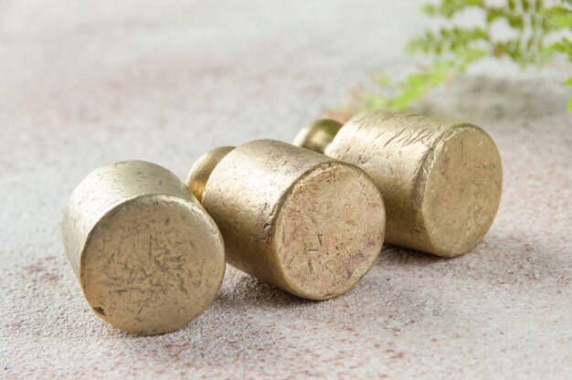 Photo three antique bronze weights for scales on concrete.