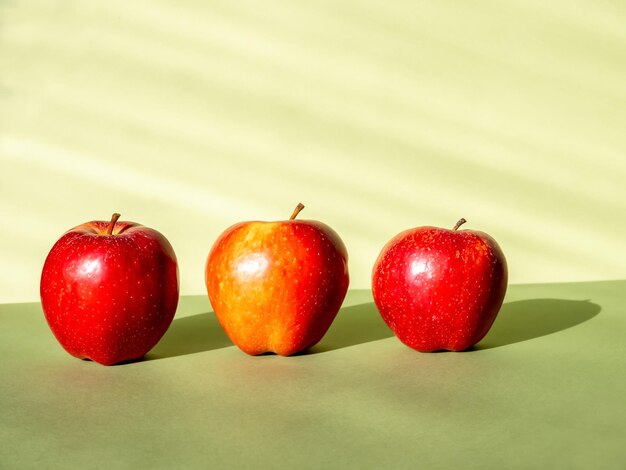 Photo three apples on a light green background