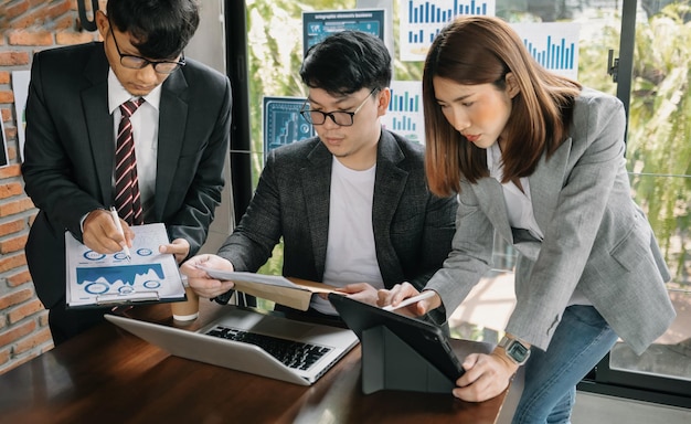 Three asia business working together with laptop on office desk in office room sitting