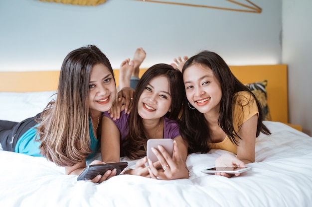 Three asian girl friends hanging out together making video call