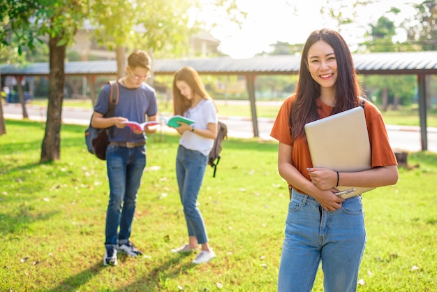 Three Asian young campus people tutoring and preparing for final examination in university