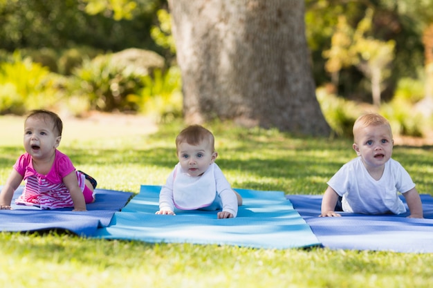 Three babies crawling on exercise-mat