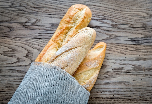 Three baguettes on the wooden surface