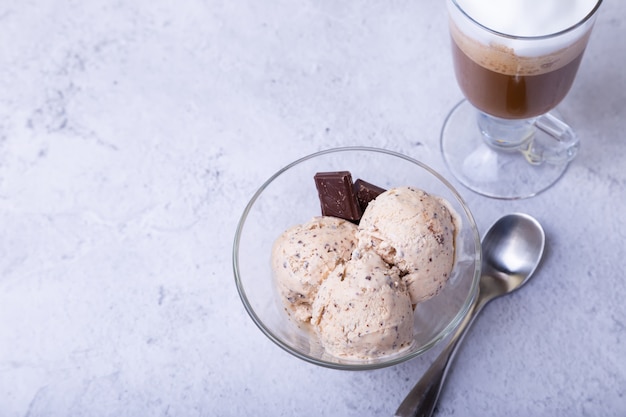 Three balls of ice cream and a cup with coffee