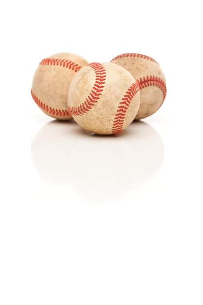 Foto tre palle da baseball isolate su bianco riflettente