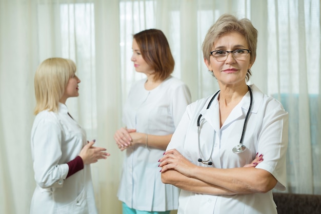 three beautiful adult women in white medical coats