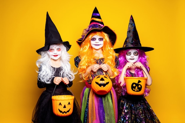 Three Beautiful girl in a witch costume scaring and making faces