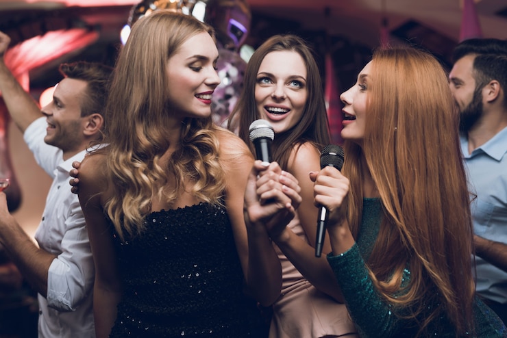 Photo three beautiful girls sing in a karaoke club