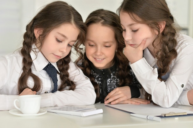 Three beautiful little girls making homework together