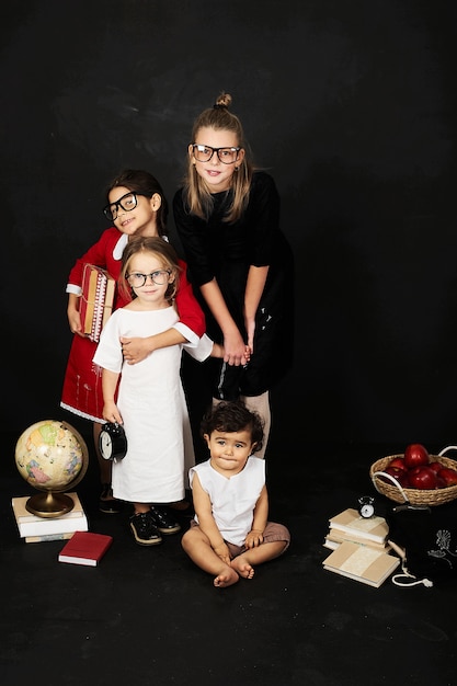 three beautiful schoolgirls from different clases and pre school boy on a black background