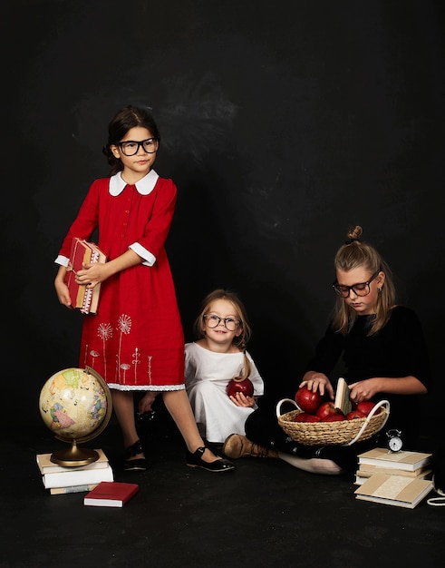 three beautiful schoolgirls from different clases and pre school boy on a black background