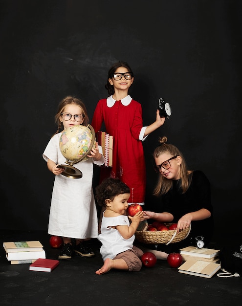 three beautiful schoolgirls from different clases and pre school boy on a black background