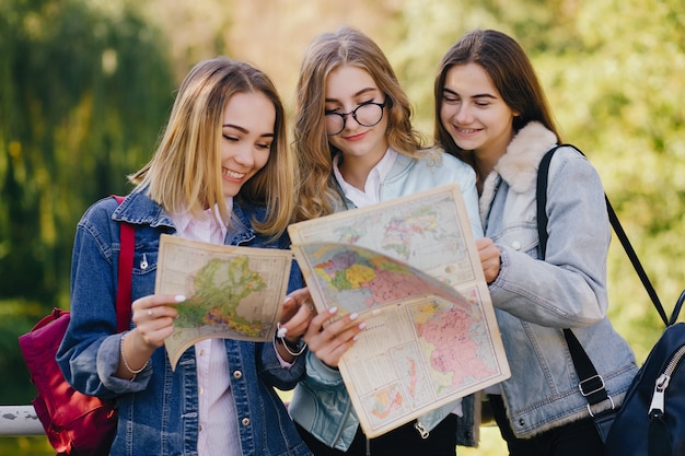 three beautiful young and stylish girls walking around looking for directions