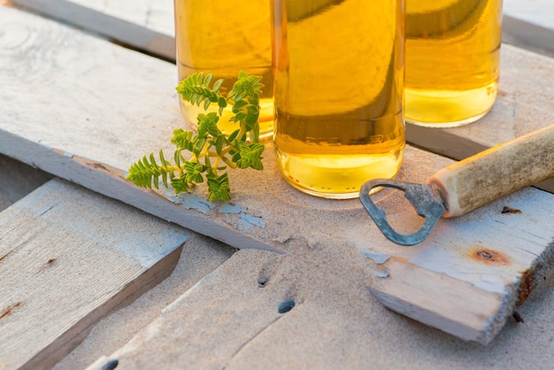 Three beer bottles standing on the rustic wooden board