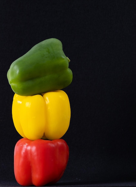 Three bell peppers on black background