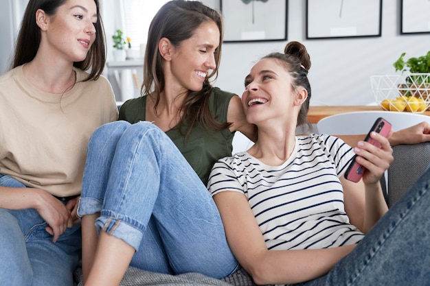 Three best friends smiling while browsing smart phone