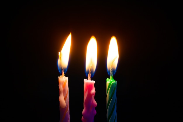 Three birthday candles on black