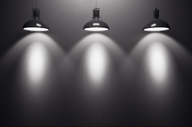 Three black lamps illuminating a blank dark wall in an empty room 3D Rendering