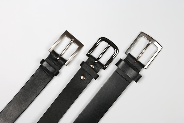 Three black leather belt on a white