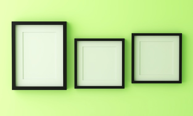 파스텔 녹색에 텍스트 또는 이미지를 삽입하기위한 세 개의 빈 검은 액자.
