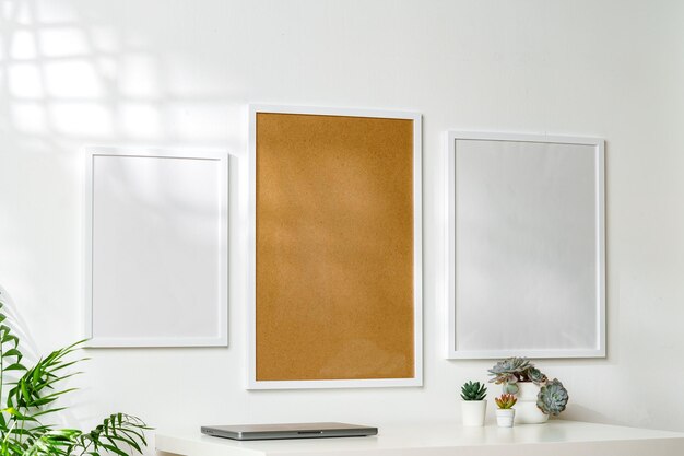 Photo three blank frames with copy space hanging on white wall