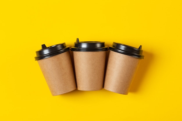 Photo three blank gray paper cups with a plastic black lid