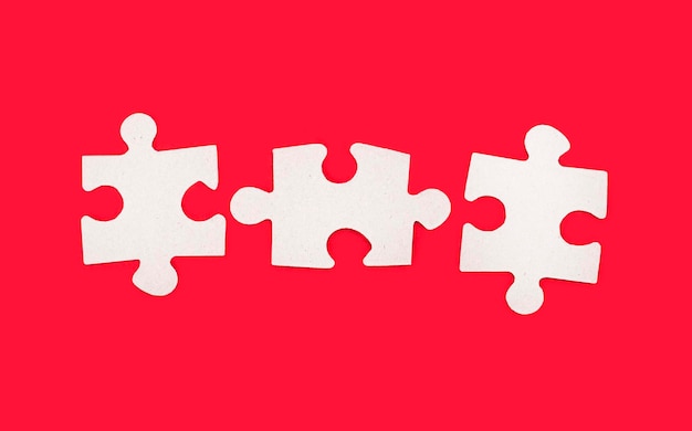 Three blank jigsaw puzzles with space for inserting text on a bright red background Copy space