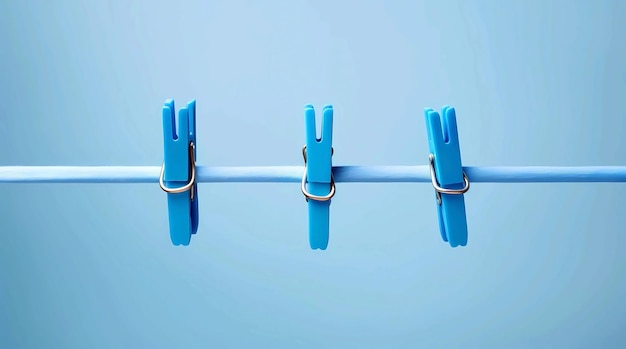 Three blue clothespins on a rope on a blue background